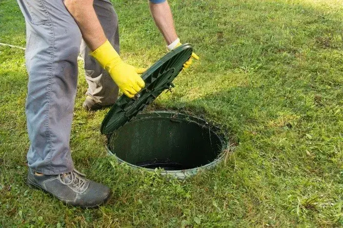 Technician providing 24/7 emergency septic services to fix a backup and protect a home
