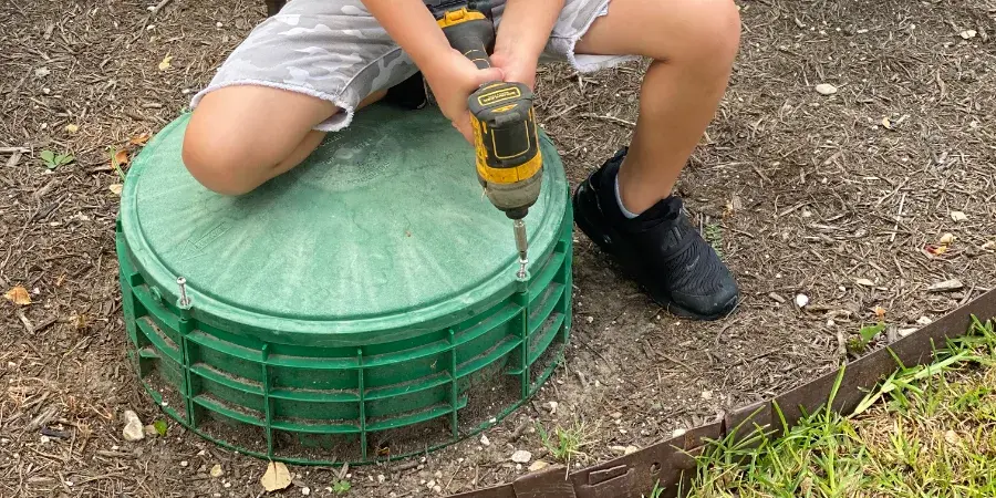 Technician installing a septic tank riser and lid for easier access and maintenance