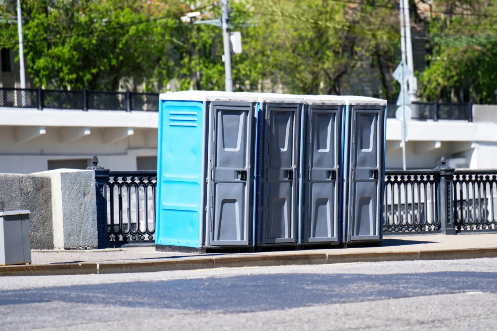 Row of clean portable toilets ready for rental and servicing at an outdoor event